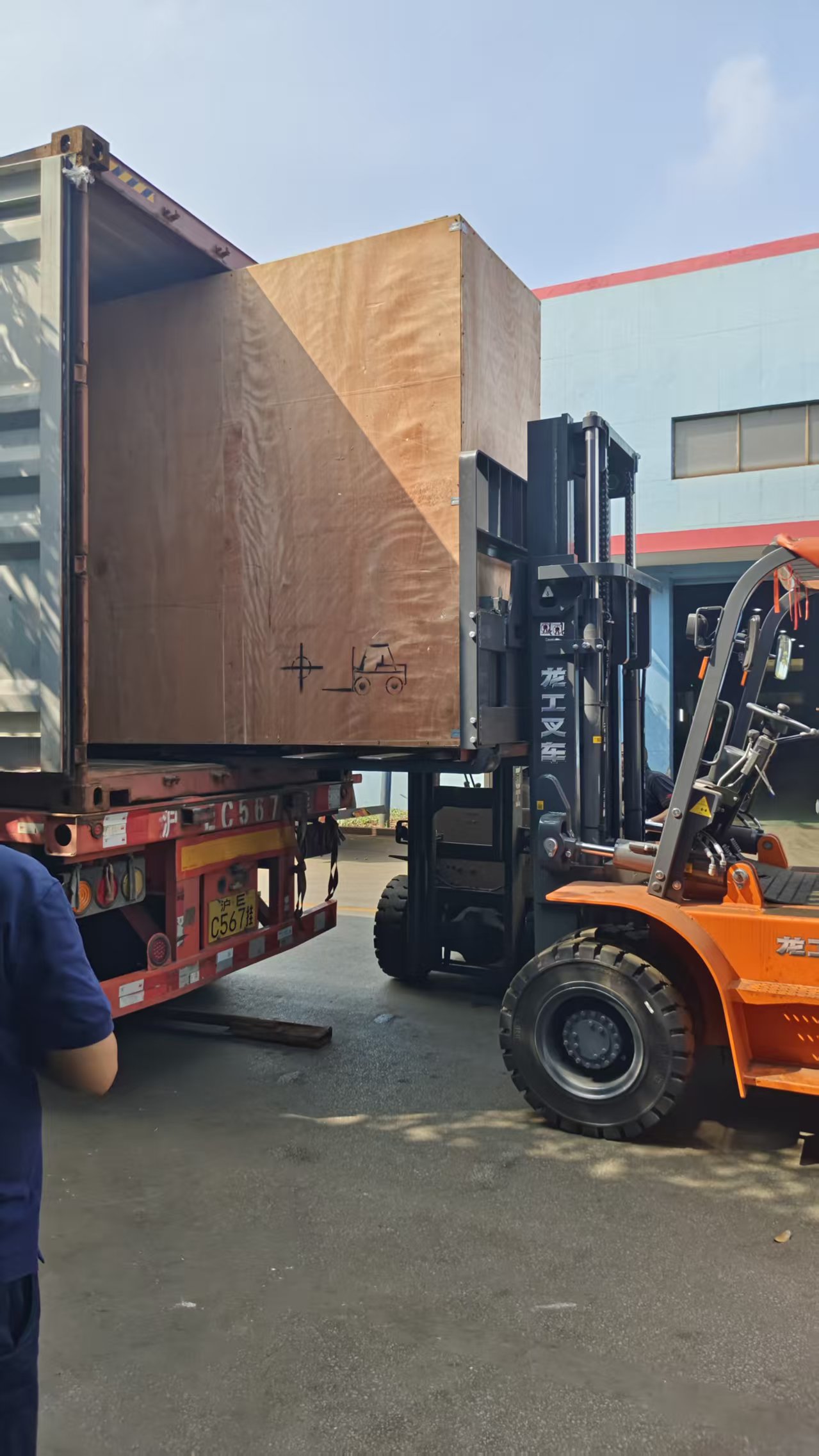 Forklift loading a machine tool case into a shipping container